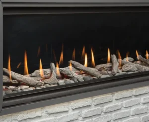 a gas fireplace with driftwood logs and stones inside